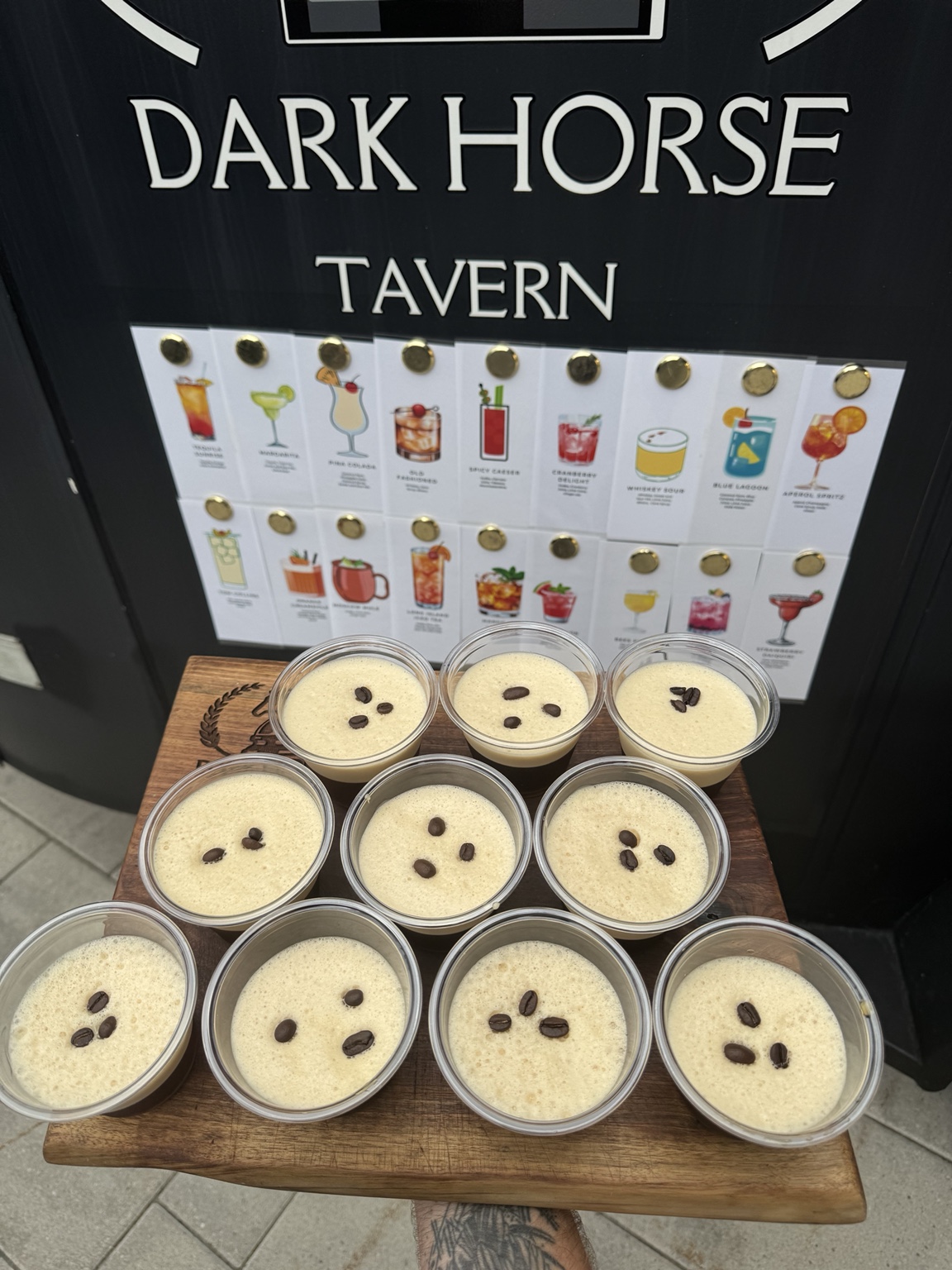 A tray of Dark Horse Tavern espresso martinis in front of the signature cocktail menu