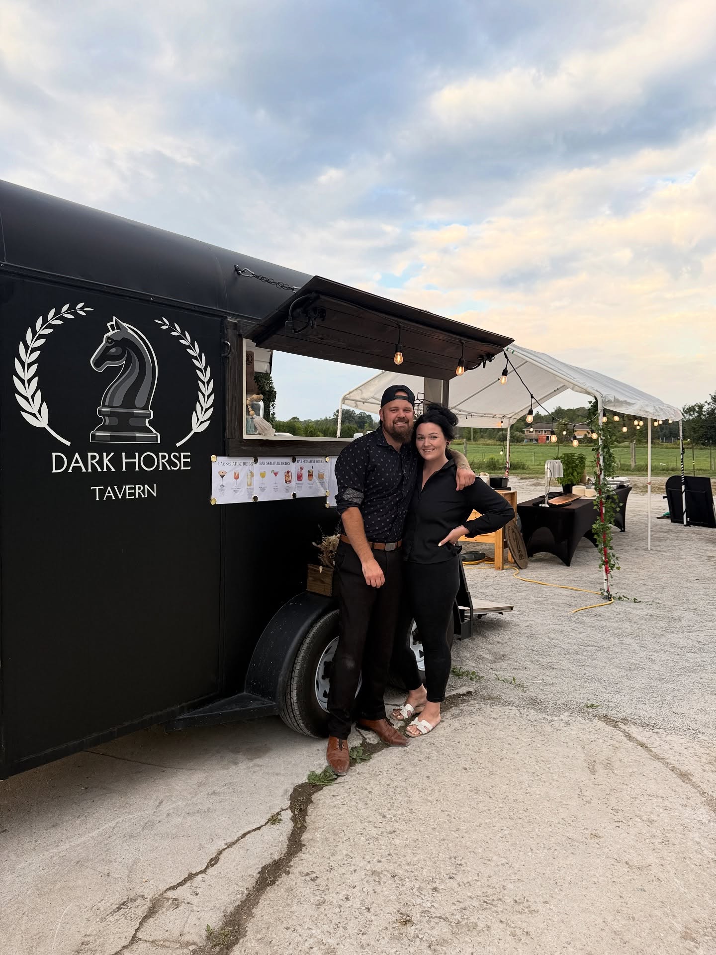 Matt and a team member beside the Dark Horse trailer at an outdoor event
